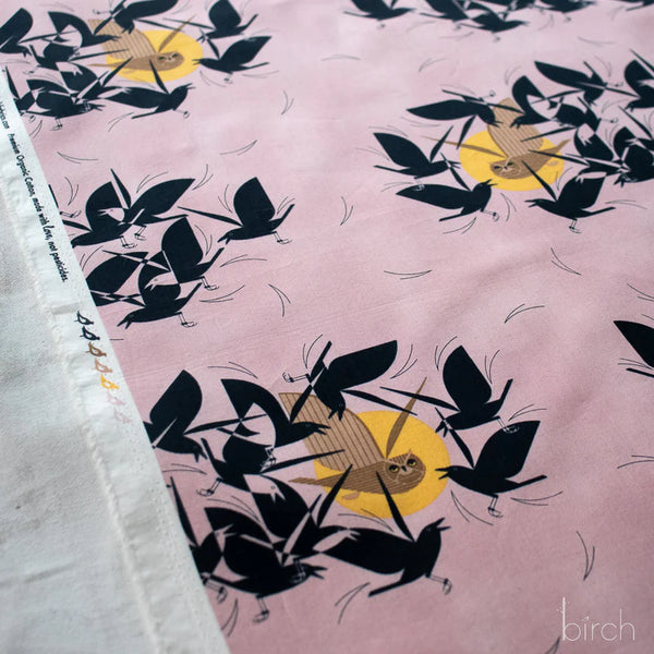 Selvage of Owltercation organic cotton poplin fabric by Charley Harper for Birch Fabrics featuring an owl and blackbirds on a muted dusky mauve background.