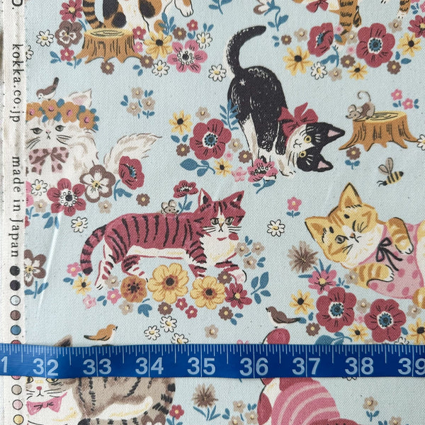 Powerful Animal Cats Garden cotton oxford fabric by Kokka in blue, style YGA-81050-1 C, shown with a tape measure for scale