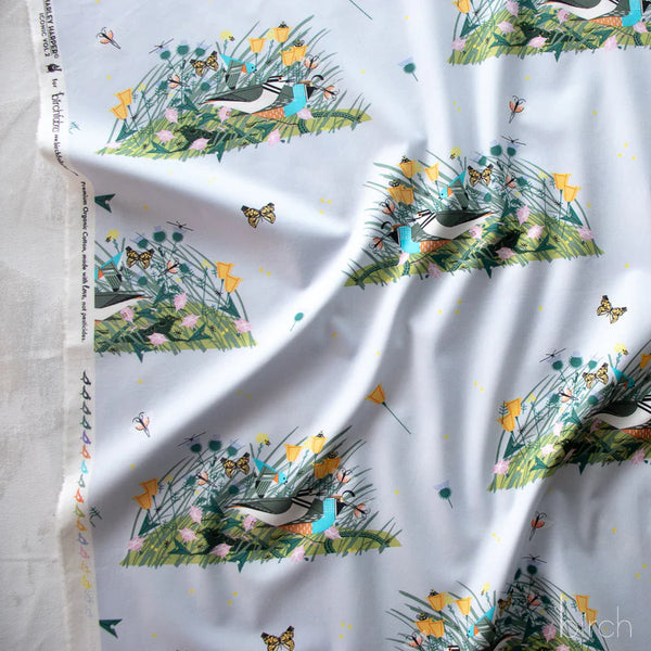 Selvage of Small Once There Was A Field organic cotton poplin fabric by Charley Harper for Birch Fabrics featuring birds, bugs, and blooms on a pale blue background.