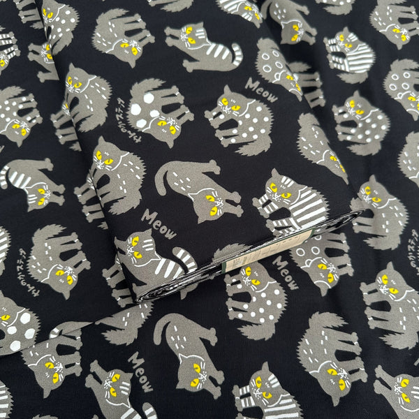Bolt of Angry Cats Cotton Oxford Fabric in Black by Cosmo Textiles featuring black cats in a Halloween cat pose with arched backs and raised fur.