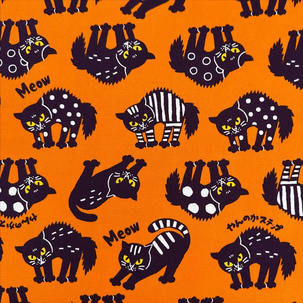 Angry Cats Cotton Oxford Fabric in Orange by Cosmo Textiles featuring black cats in a Halloween cat pose with arched backs and raised fur.