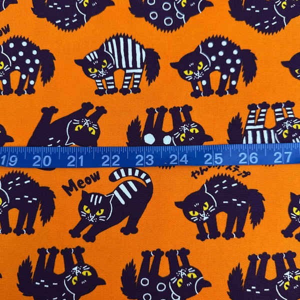 Scale of Angry Cats Cotton Oxford Fabric in Orange by Cosmo Textiles featuring black cats in a Halloween cat pose with arched backs and raised fur.