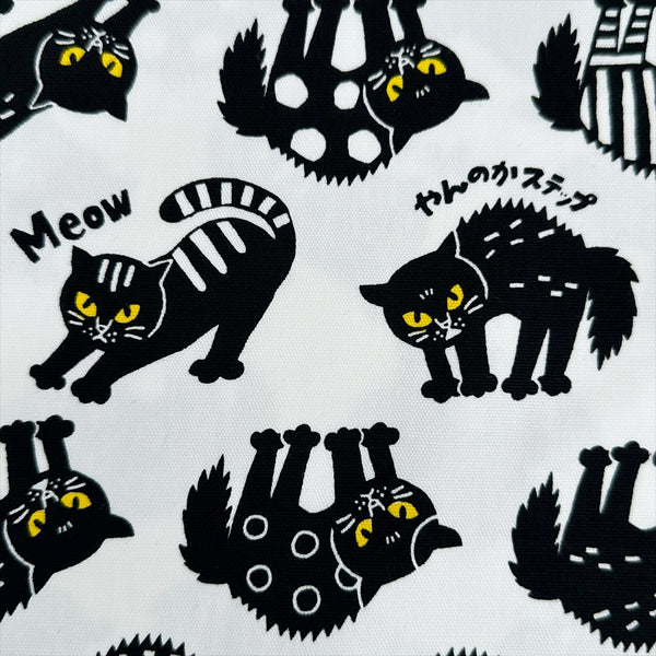 Close up of Angry Cats Cotton Oxford Fabric in White by Cosmo Textiles featuring black cats in a Halloween cat pose with arched backs and raised fur.