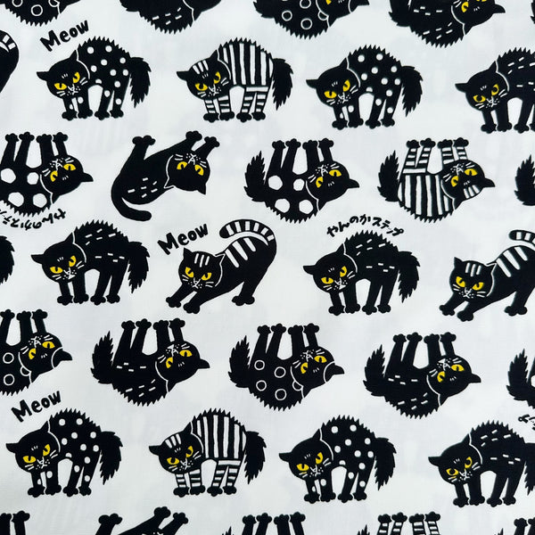 Angry Cats Cotton Oxford Fabric in White by Cosmo Textiles featuring black cats in a Halloween cat pose with arched backs and raised fur.