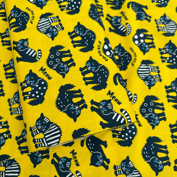 Bolt of Angry Cats Cotton Oxford Fabric in Yellow by Cosmo Textiles featuring black cats in a Halloween cat pose with arched backs and raised fur.