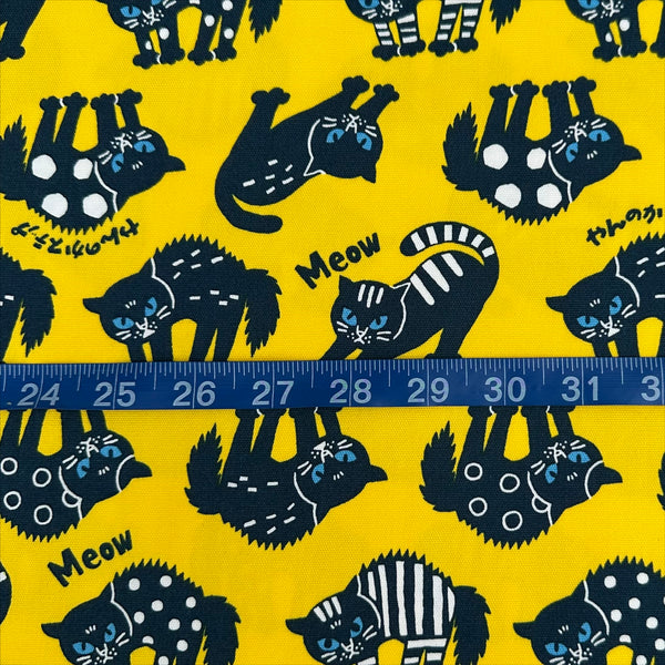 Scale of Angry Cats Cotton Oxford Fabric in Yellow by Cosmo Textiles featuring black cats in a Halloween cat pose with arched backs and raised fur.