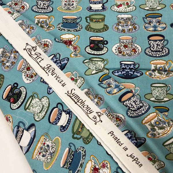 Selvage of Art Nouveau Symphony Tea Cups cotton fabric in teal