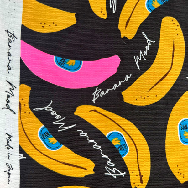 Selvage of Banana Mood cotton Oxford fabric in neon pink and black Japanese import fabric featuring a banana print
