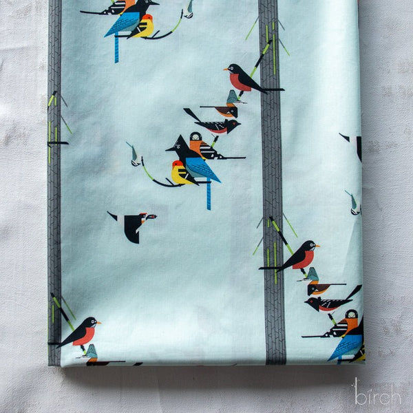 Stock photo of Birds on Pine Organic Poplin Fabric by Charley Harper for Birch Fabrics, style CH-164, featuring birds and pine trees, on pale blue background