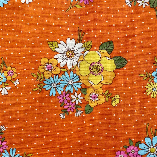 Close up of Bloom Garland Retro Floral and Polka Dot Cotton Fabric by Koko Seki, in orange, imported from Japan