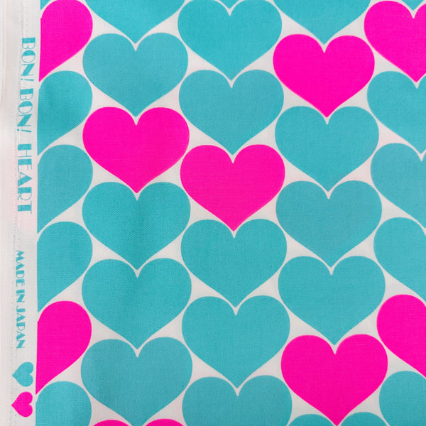Selvage of Bon Bon Heart cotton Oxford fabric in neon pink and aqua blue featuring a large-scale heart print, imported from Japan