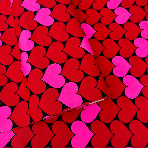 Bolt of Bon Bon Heart cotton Oxford fabric in neon pink and black featuring a large-scale heart print, imported from Japan