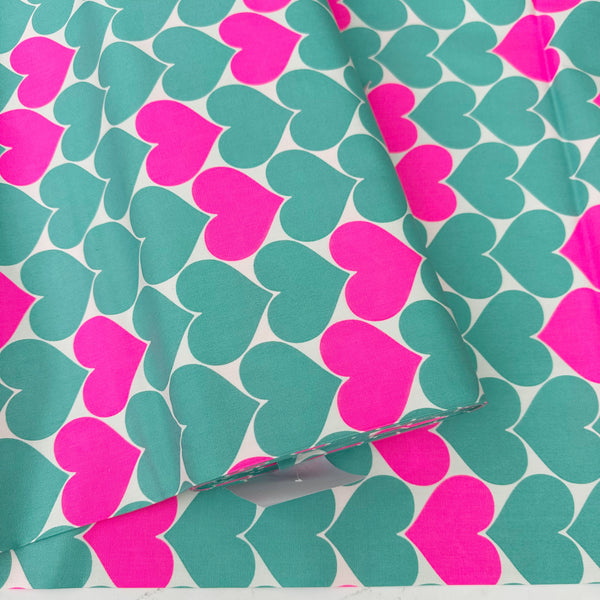 Bolt of Bon Bon Heart cotton Oxford fabric in neon pink and green featuring a large-scale heart print, imported from Japan