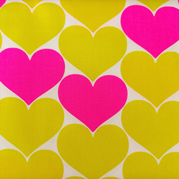 Close up of Bon Bon Heart cotton Oxford fabric in neon pink and yellow featuring a large-scale heart print, imported from Japan
