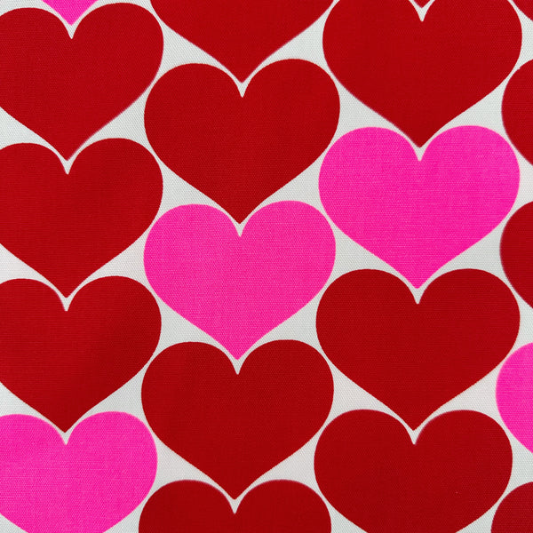 Close up of Bon Bon Heart cotton Oxford fabric in red and white featuring a large-scale heart print, imported from Japan