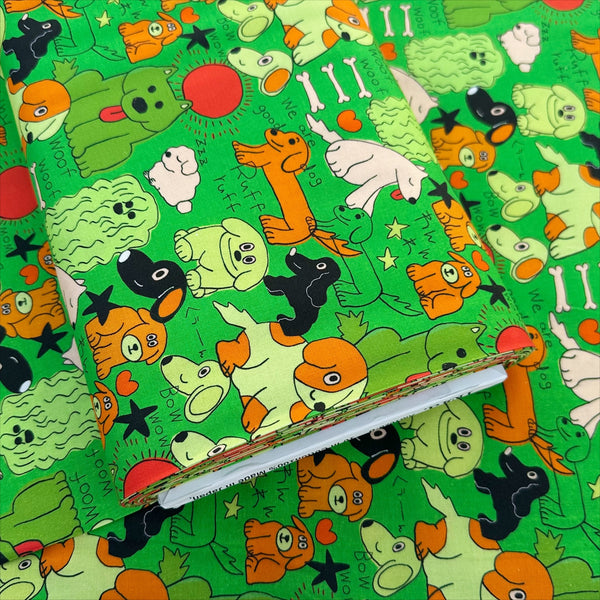 Bolt of Bow Wow Pop! cotton fabric in green by Nora featuring playful dogs on a green background, imported from Japan