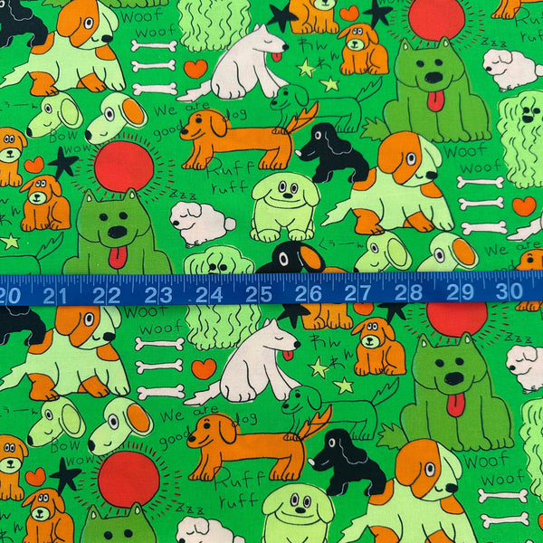 Scale of Bow Wow Pop! cotton fabric in green by Nora featuring playful dogs on a green background, imported from Japan