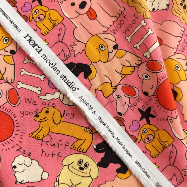 Selvage of Bow Wow Pop cotton fabric by Nora featuring playful illustrated dogs in a hand-drawn style on a bright pink background, imported from Japan