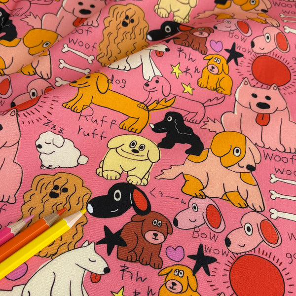 Stock photo of Bow Wow Pop cotton fabric by Nora featuring playful illustrated dogs in a hand-drawn style on a bright pink background, imported from Japan