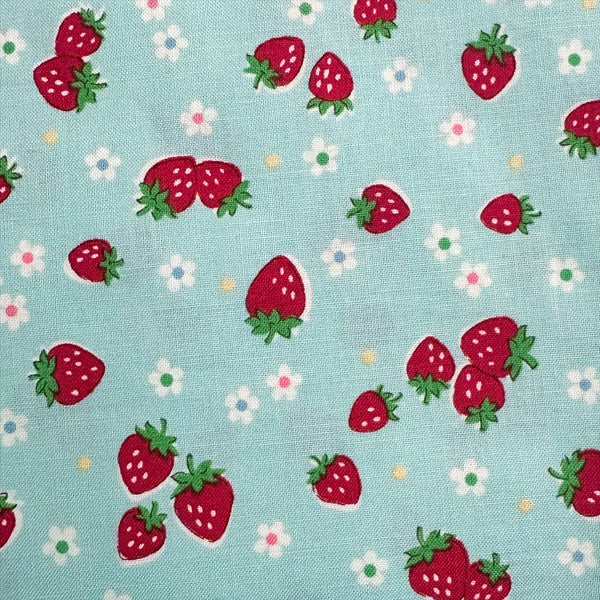 Close-up of Candy Berry blue cotton fabric with strawberry print from Atsuko Matsuyama Yuwa 30’s Collection, perfect for quilting and crafts.
