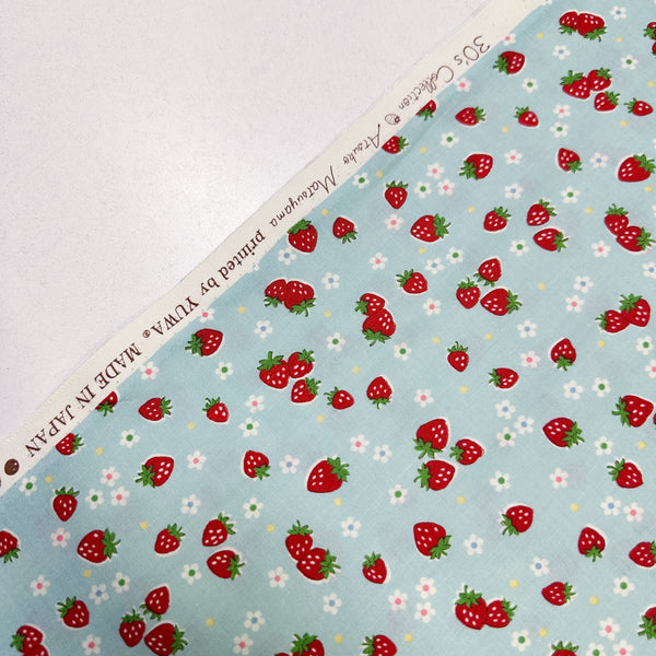 Selvage of Candy Berry blue cotton fabric with strawberry print from Atsuko Matsuyama Yuwa 30’s Collection, perfect for quilting and crafts.