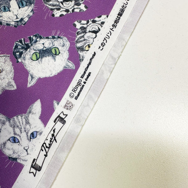 Selvage of Cat Faces cotton oxford fabric in purple by illustrator Ringo, imported from Japan