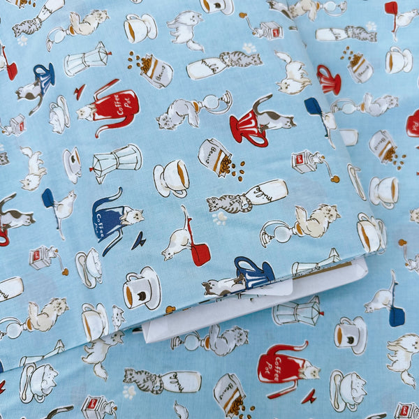 Bolt of Cat and Coffee cotton fabric by Handworks featuring playful cats and coffee-themed illustrations on a blue background