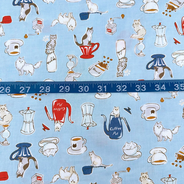 Scale of Cat and Coffee cotton fabric by Handworks featuring playful cats and coffee-themed illustrations on a blue background
