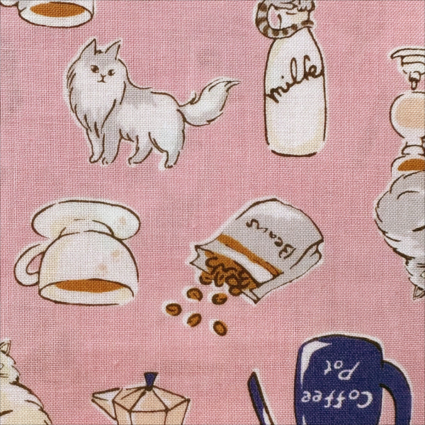 Close up of Cat and Coffee cotton fabric by Handworks featuring playful cats and coffee-themed illustrations on a pink background