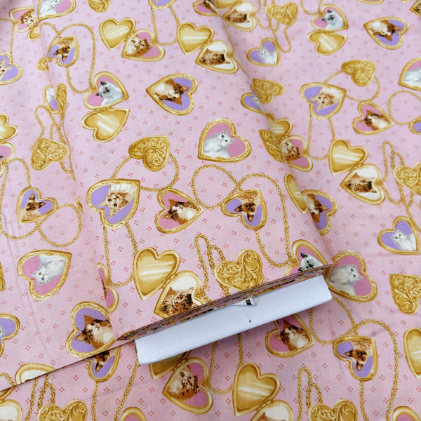 Bolt of Cat Portrait Locket cotton fabric by Handworks featuring vintage-style cat portraits inside heart-shaped lockets on a pink background