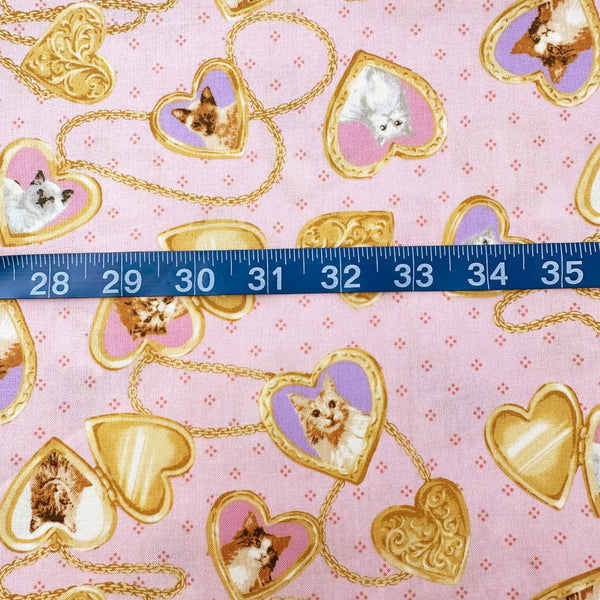 Scale of Cat Portrait Locket cotton fabric by Handworks featuring vintage-style cat portraits inside heart-shaped lockets on a pink background