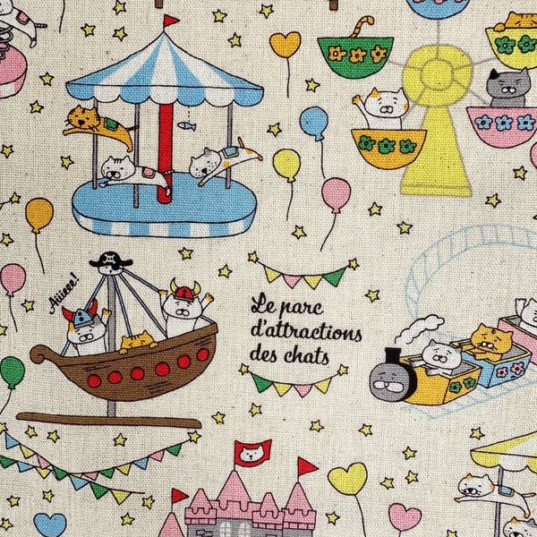 Close up of Catland Cotton Linen Canvas Fabric by Cotton Kobayashi, style KTS-7183A, featuring cats at an amusement park, in cream, imported from Japan