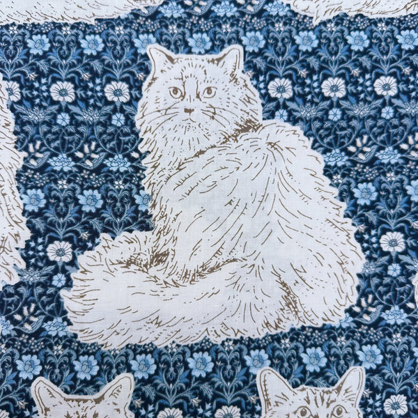 Close up of Cats Playground cotton fabric in blue by Handworks Japan featuring large-scale cats on a petite floral background