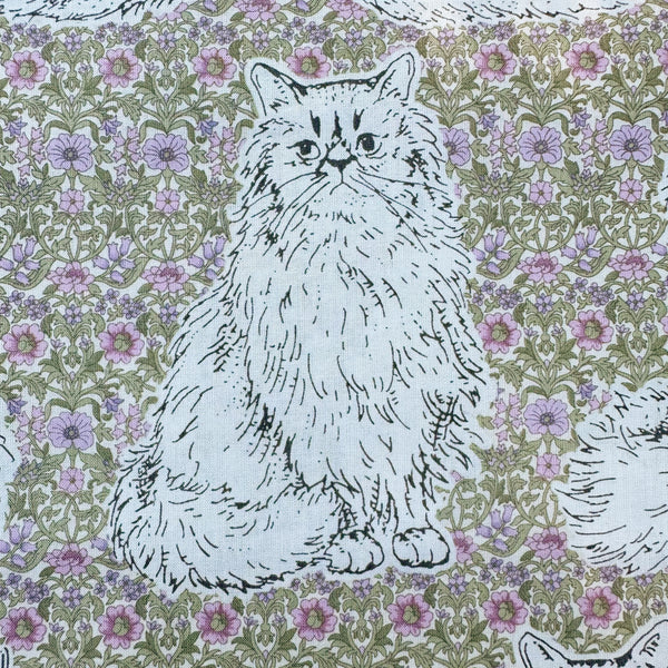 Close up of Cats Playground cotton fabric in green and purple by Handworks Japan featuring large-scale cats on a petite floral background