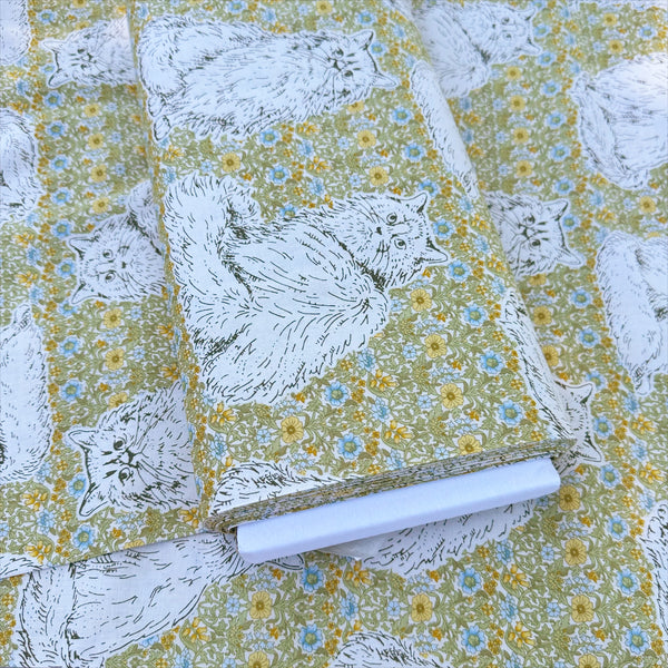 Bolt of Cats Playground cotton fabric in green and yellow by Handworks Japan featuring large-scale cats on a petite floral background
