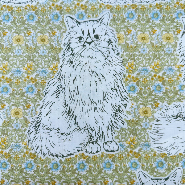 Close up of Cats Playground cotton fabric in green and yellow by Handworks Japan featuring large-scale cats on a petite floral background
