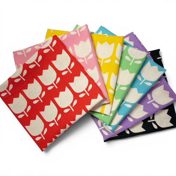 7 piece fat quarter bundle of Color Palette Tulips cotton fabric featuring red, pink, yellow, green, blue, purple, and black tulips on a natural cotton background