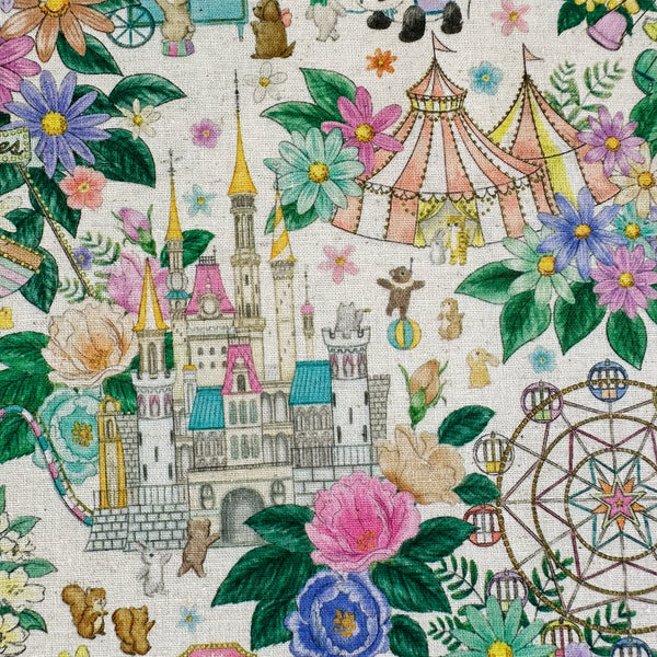 Close up of Decoration Park cotton linen fabric by Yukiemon for Hokkoh featuring a charming delicately illustrated vintage-style fun fair scene with florals, carousel rides, circus tents, and whimsical animals on a natural background, imported from Japan