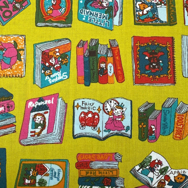 Close up of Dreaming Cat Story Books cotton fabric in chartreuse, imported from Japan
