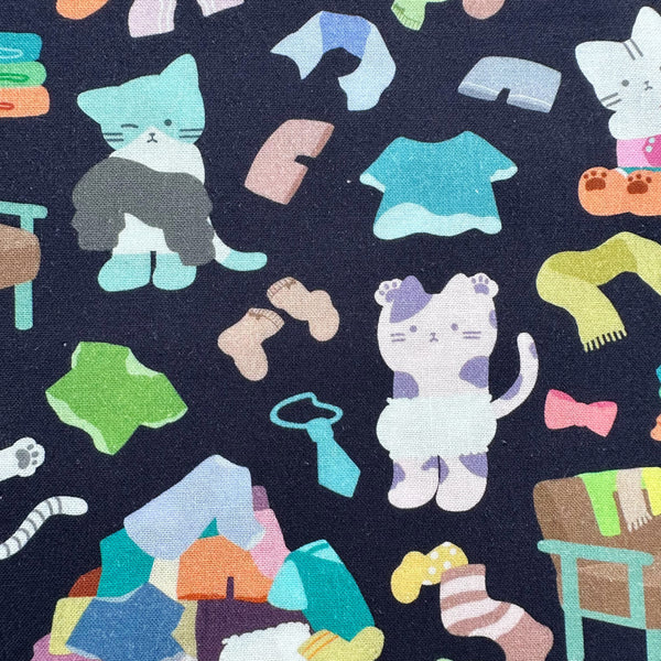 Close up of Dressed Up Cats cotton fabric in midnight by Nora featuring cats with clothing and laundry illustrations imported from Japan