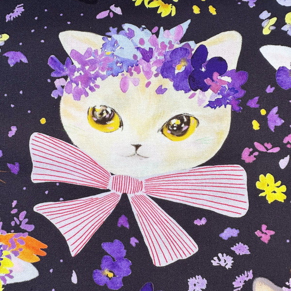 Close up of Dressed Up Cats cotton fabric in purple by Nora featuring cats with ribbons and flower crowns imported from Japan