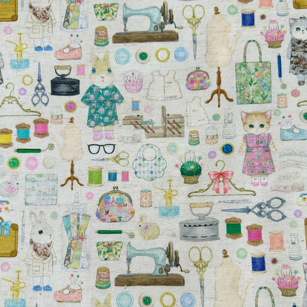 Dressmaker cotton linen fabric by Yukiemon for Hokkoh featuring delicately illustrated sewing notions, dressmaking tools, vintage sewing machines, and sweet bunny and kitty dressmakers on a natural background, imported from Japan
