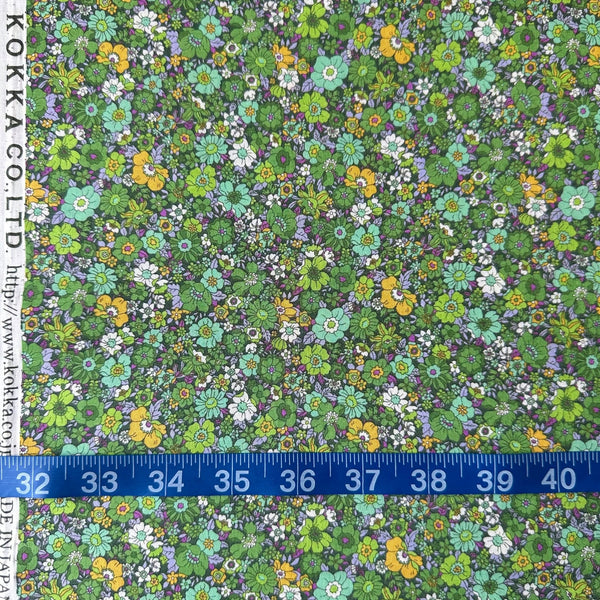 Flownny Retro Floral cotton lawn fabric by Kokka in green, shown with a tape measure for scale, style NFA-1030-31 D