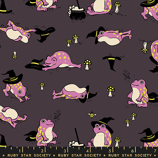 Scale of Frogmiliars cotton fabric by Ruby Star Society featuring frogs and witch hats on an eggplant purple background.