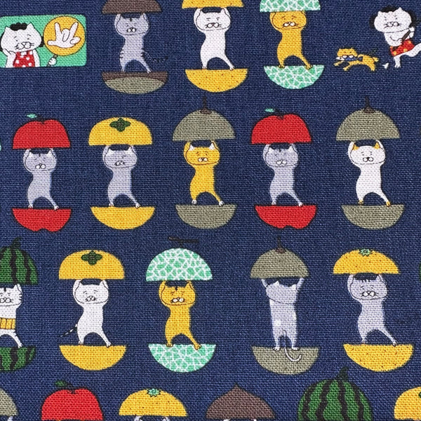 Close up of Fruit Cats Canvas Fabric in Indigo by Cotton Kobayashi – cats standing inside halved fruits on cotton linen canvas, imported from Japan