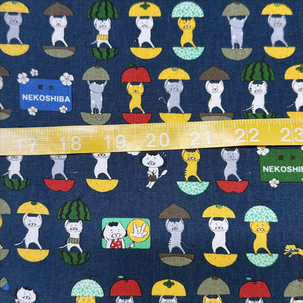 Scale of Fruit Cats Canvas Fabric in Indigo by Cotton Kobayashi – cats standing inside halved fruits on cotton linen canvas, imported from Japan