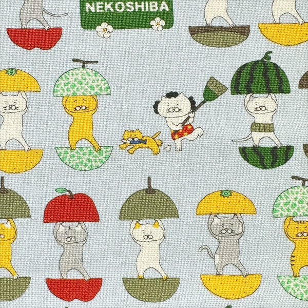 Close up of Fruit Cats Canvas Fabric in Light Blue by Cotton Kobayashi – cats standing inside halved fruits on cotton linen canvas, imported from Japan
