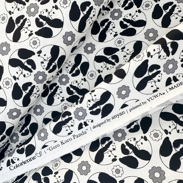 Selvage of Goro Koro Panda Cotton Oxford Fabric in White by Anyan for Cotorienne and Yuwa featuring adorable rolling pandas on a white background.