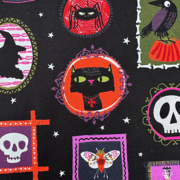 Close up of Hocus Pocus Ghoulish Gallery cotton fabric by Helen Black featuring spooky framed portraits on a black background