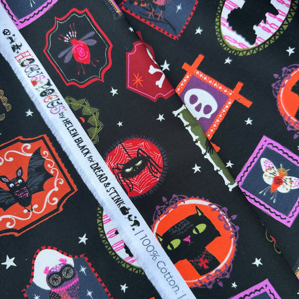Selvage of Hocus Pocus Ghoulish Gallery cotton fabric by Helen Black featuring spooky framed portraits on a black background